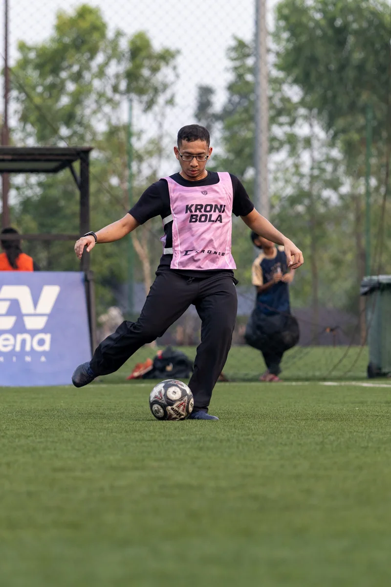 A KroniBola player striking the ball in a pink training bib